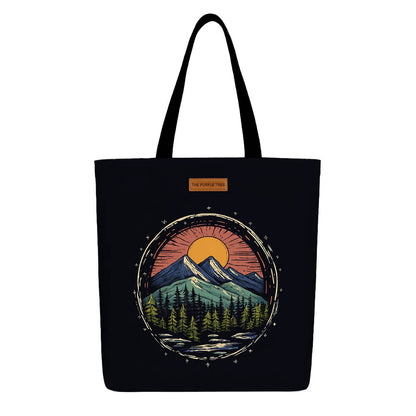 A black tote bag featuring a scenic mountain landscape design.