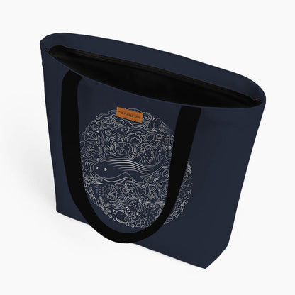 A blue tote bag displaying a charming whale illustration, emphasizing oceanic themes.