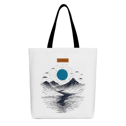 A tote bag featuring a serene mountain landscape under a vibrant blue moon.